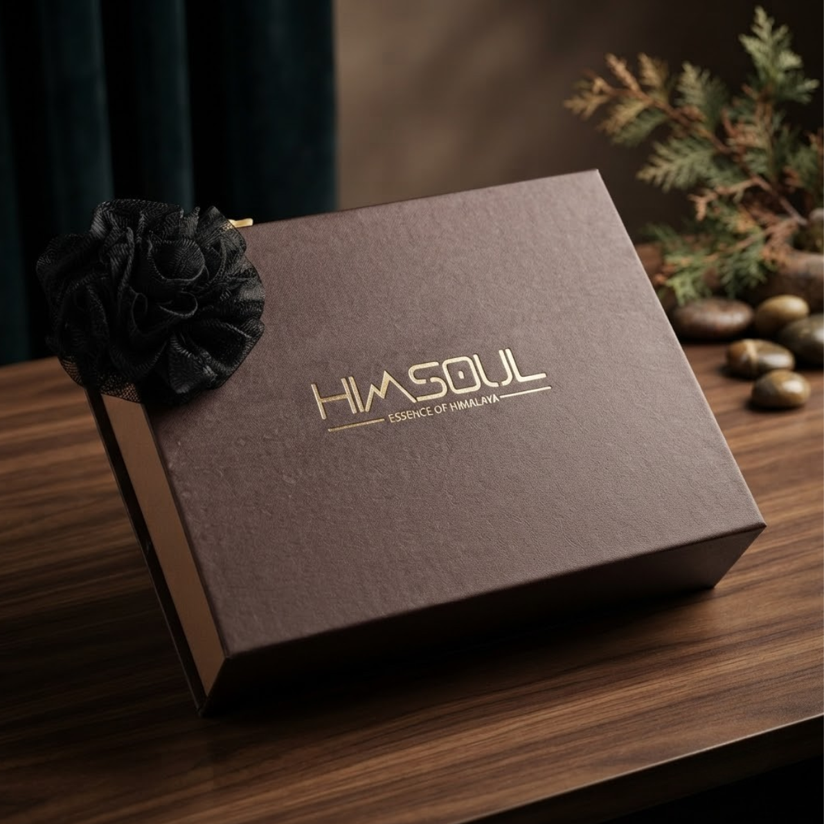 Himsoul mocha brown rigid gift box with gold foil embossed logo and black mesh flower accent on a dark wood table.